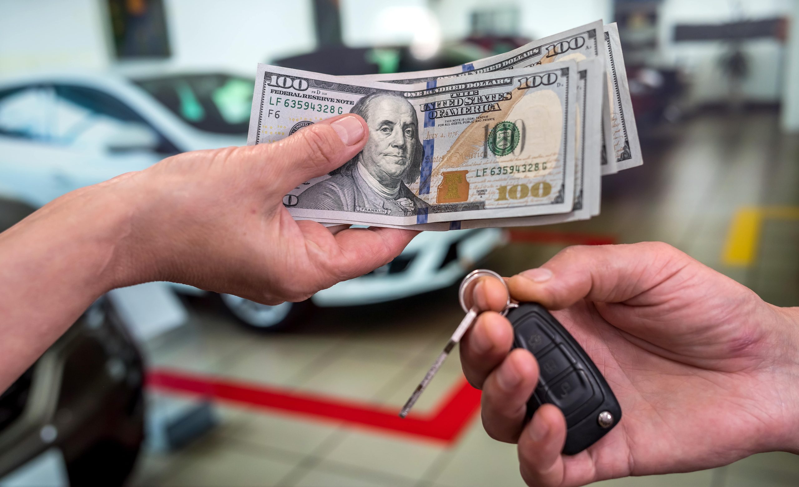Person handing money over in exchange for car keys