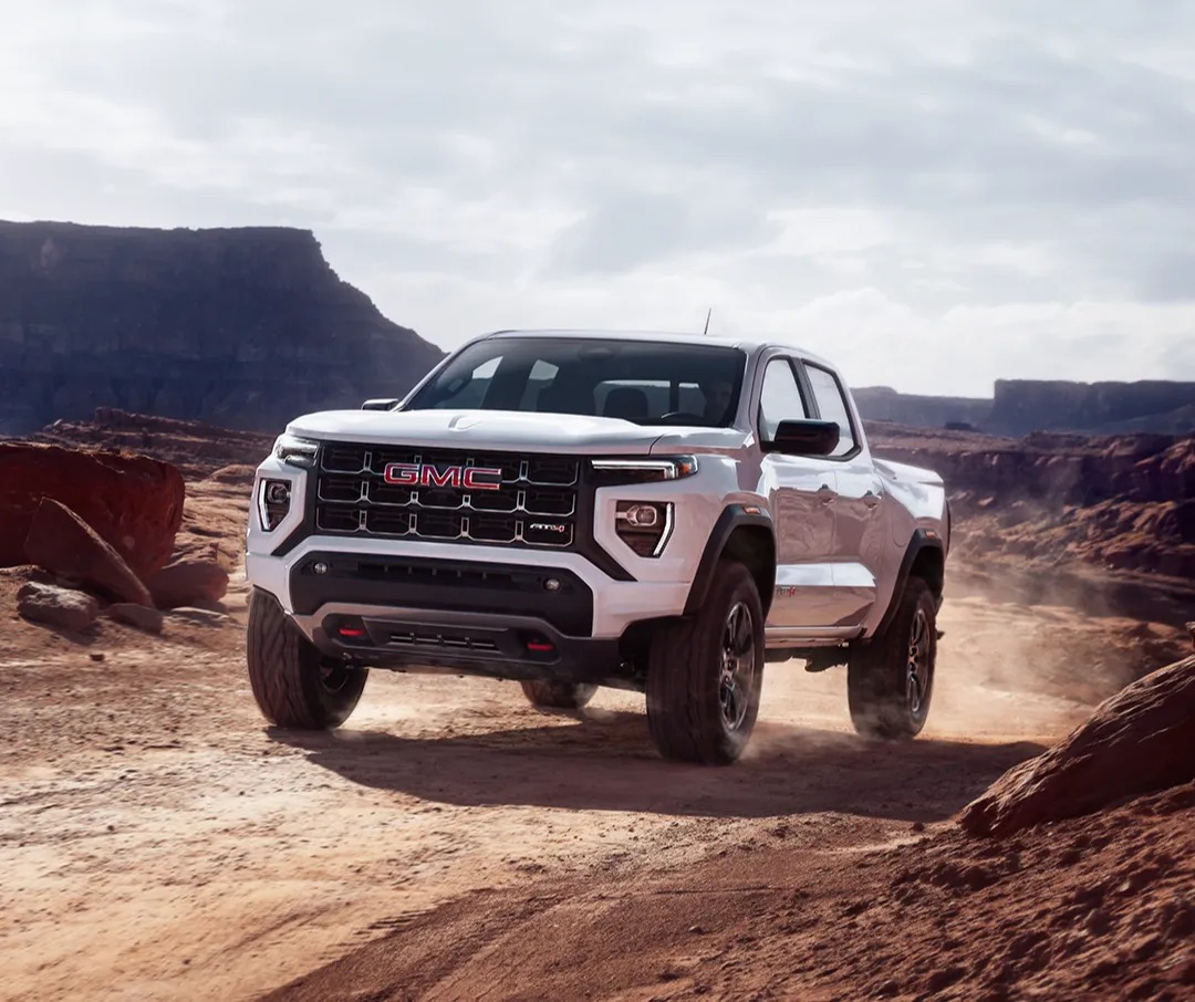 2025 GMC Canyon AT4 driving over a dirt road in the desert
