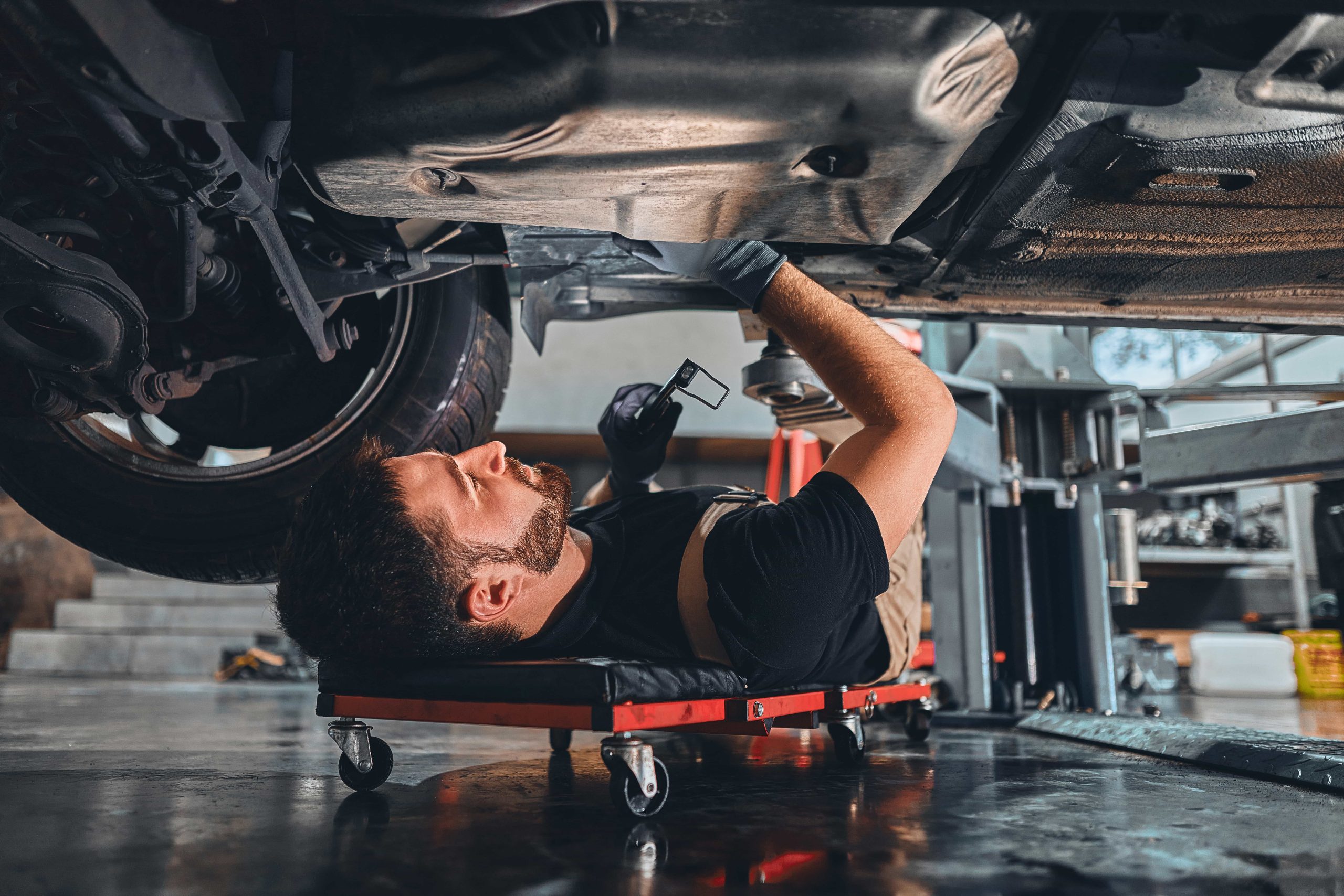 Mechanic Checking Out the Underside of a Car