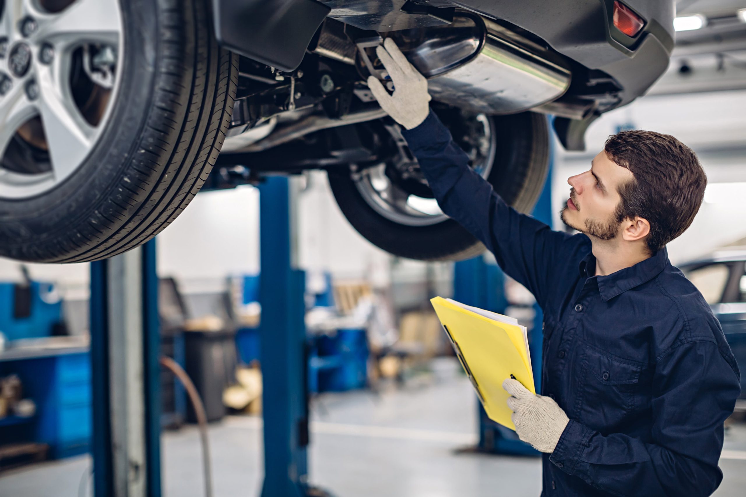 Mechanic checking the steering alignment on a GMC vehicle
