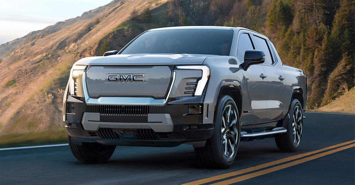 2025 GMC Sierra EV Denali Truck driving on a highway through the mountains