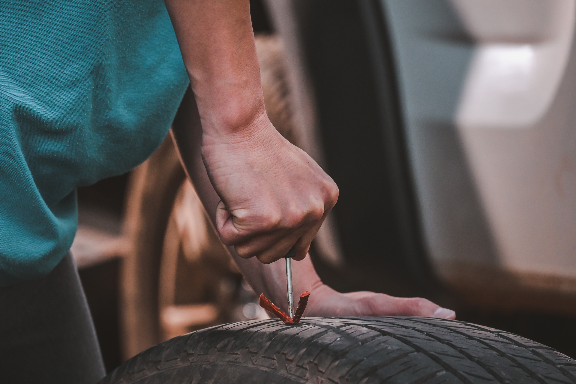 Man patching a leaky tire with a tool