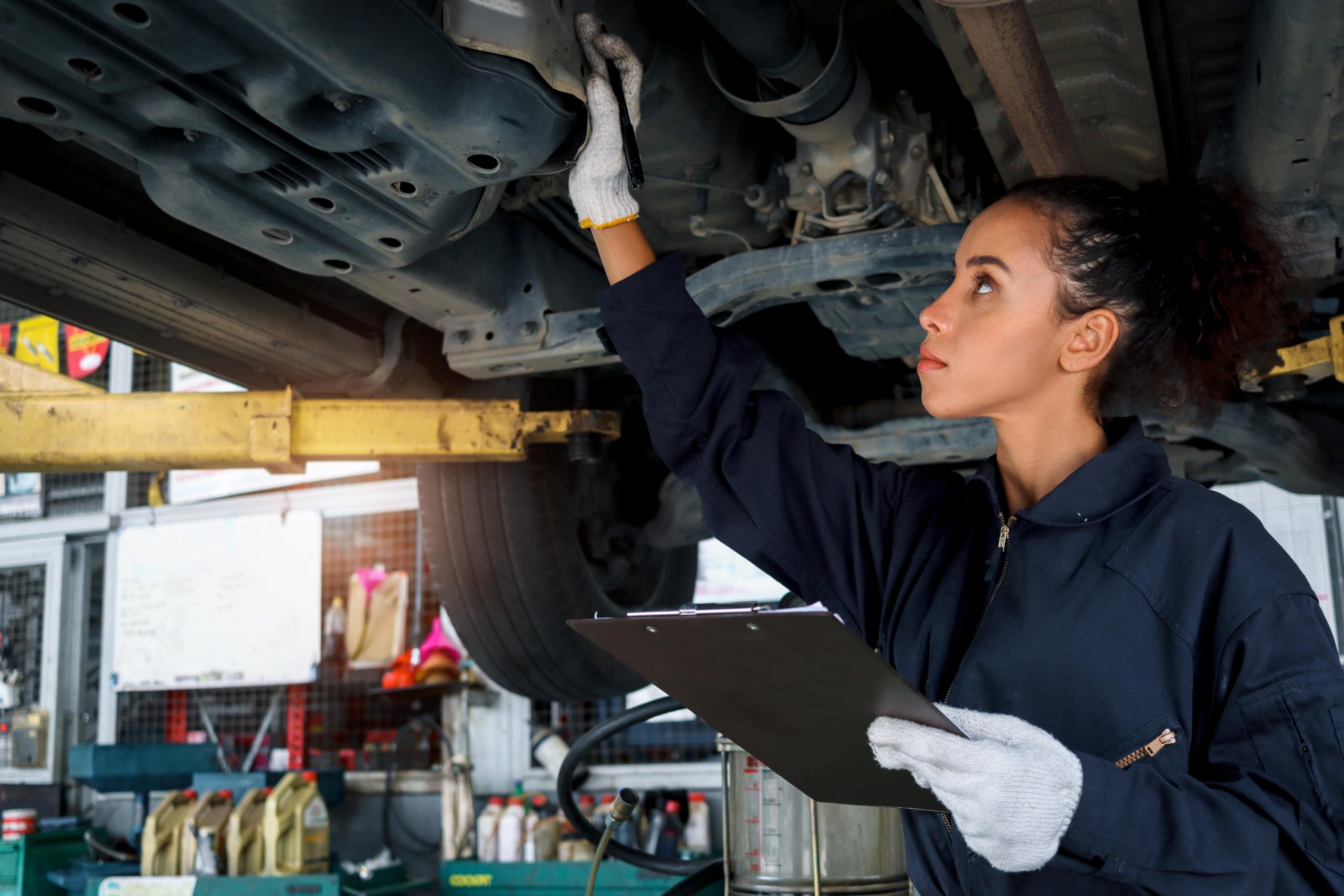 Mechanic inspecting the underside of a car
