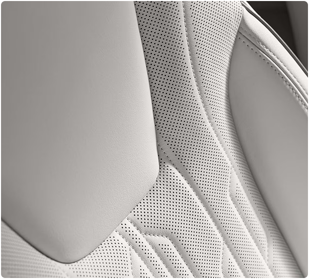Close-up of a light perforated leather seat with quilted stitching