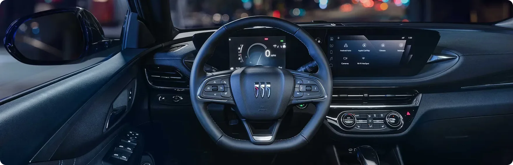 Buick Envista steering wheel and ultrawide infotainment display lit at night
