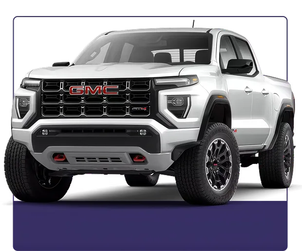 White GMC Canyon AT4 shown from the front three-quarter angle on a dark studio background