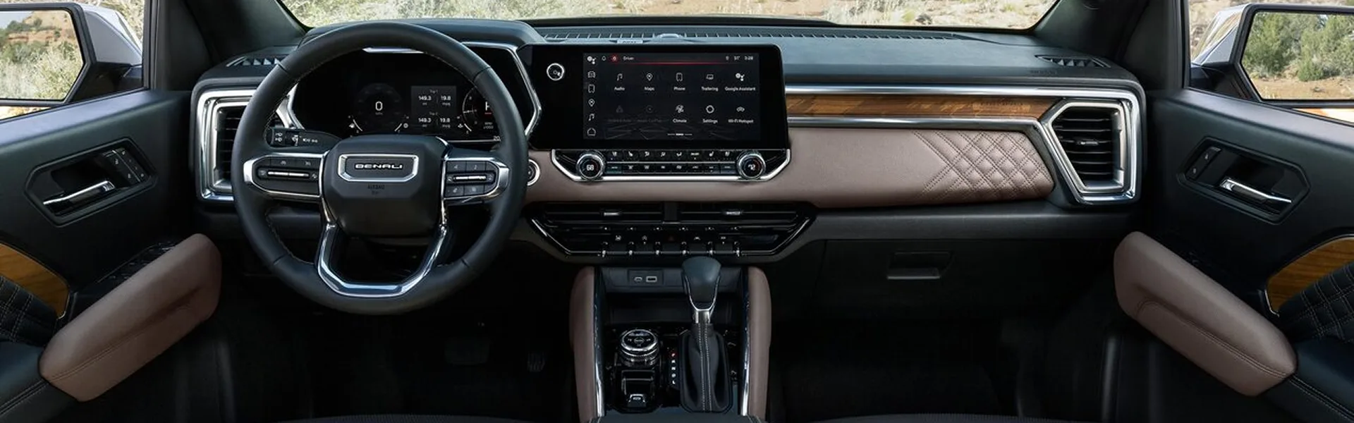 Wide view of the GMC Canyon Denali's dashboard with Teak accents and the centre touchscreen