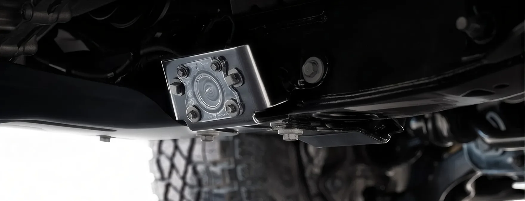 Close-up of the Canyon's underbody camera mounted beneath the chassis beside an off-road tyre