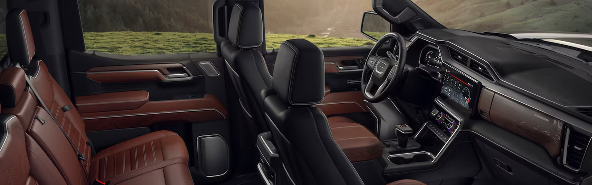 GMC Sierra 1500 Denali Ultimate cabin with brown leather seats, seen through the open doors