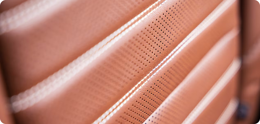 Close-up of brown perforated leather with contrast stitching