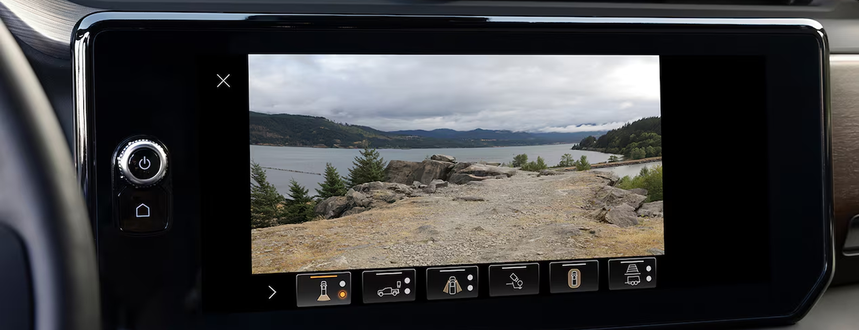 GMC Sierra 1500 touchscreen showing a camera view of a gravel lot beside a lake