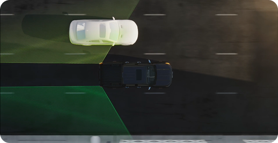 Overhead illustration of a GMC vehicle with green blind zone areas and a white car alongside in the next lane