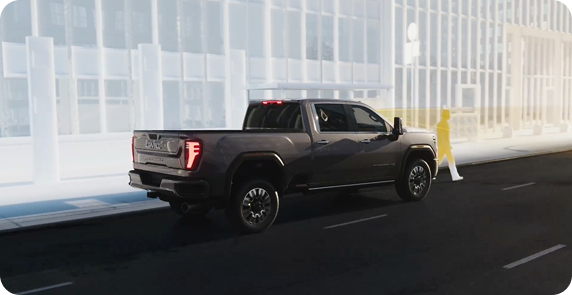Illustration of a dark gray GMC truck stopped on a city street, with a pedestrian highlighted in yellow in front of it