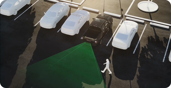 Overhead illustration of a black GMC truck backing out of a parking space, with a green zone behind it and a pedestrian walking past