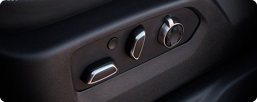 Close-up of the power seat adjustment controls on the side of a GMC Sierra HD front seat