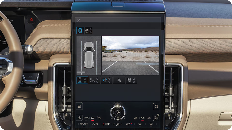 Center touchscreen showing an overhead view of the truck beside a rear camera view of a parking lot