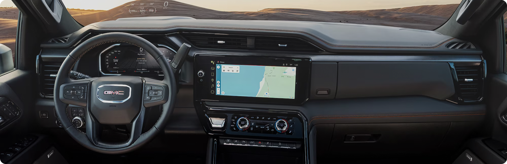 GMC Sierra HD dashboard with the steering wheel, digital driver display and center touchscreen showing a map
