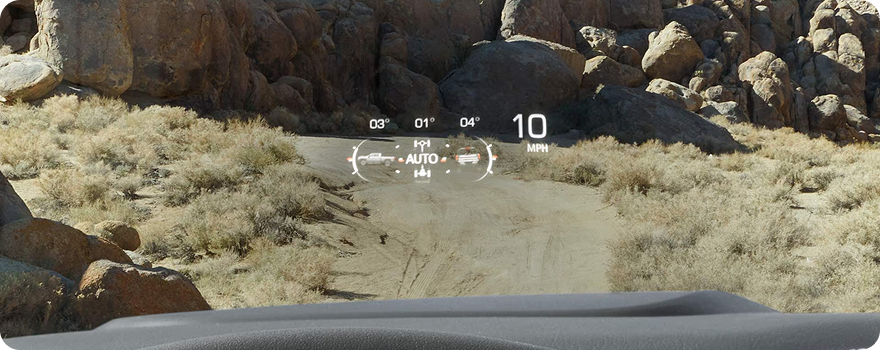 Head-Up Display projecting speed and off-road information onto the windshield above a rocky desert trail