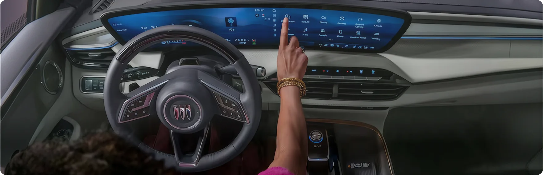 Driver touching the ultrawide 30-inch diagonal screen in the Enclave Avenir