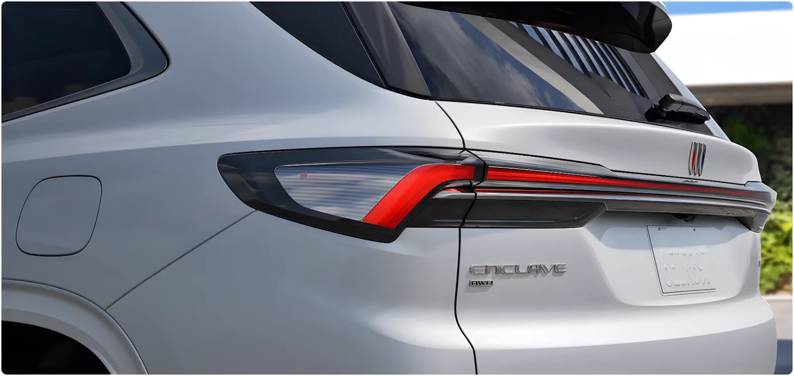 Close-up of the rear light bar and Enclave badge on a white Buick Enclave