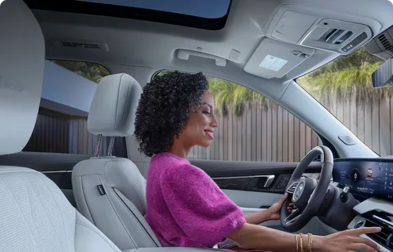 Driver at the wheel of an Enclave Avenir with light Twilight Ash interior trim