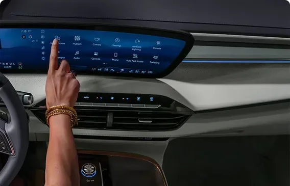 Hand reaching to the Enclave Avenir ultrawide display with blue ambient cabin lighting