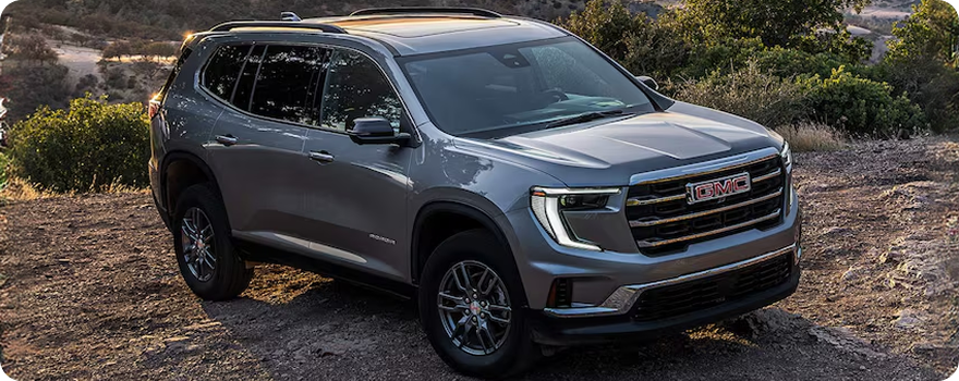 Gray GMC Acadia parked on a hillside, seen from above the front passenger corner