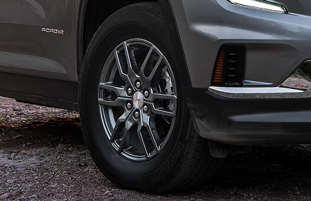 Front wheel of a gray GMC Acadia Elevation with a painted aluminum wheel