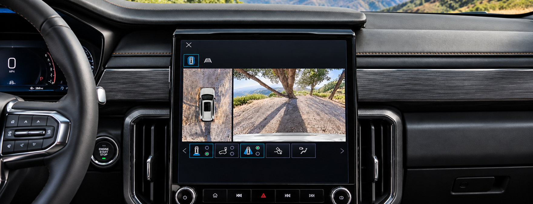 GMC Acadia center touchscreen showing an overhead camera view beside a forward camera view