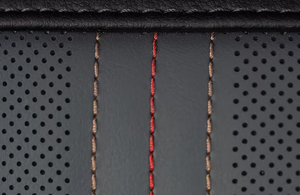 Close-up of perforated Acadia AT4 seat upholstery with red and tan stitching