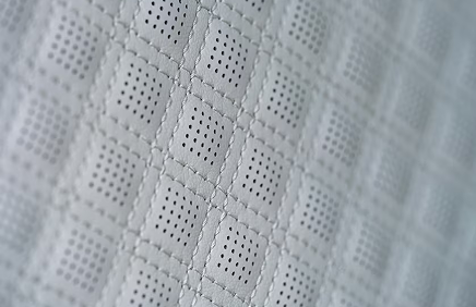 Close-up of light gray quilted, perforated leather in the Acadia Denali