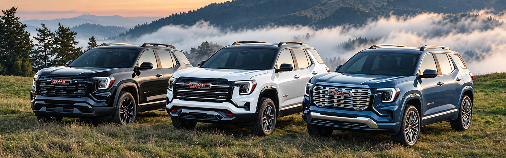 Black, white and blue 2027 GMC Terrain models lined up on a mountain ridge above the clouds