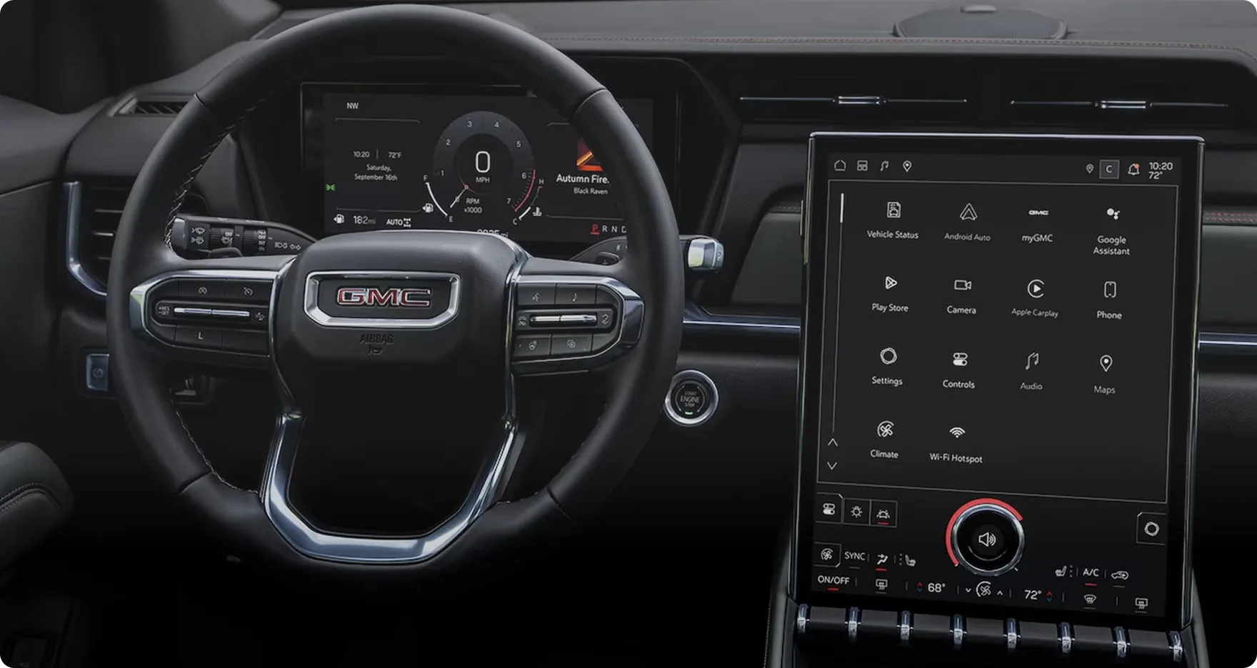 The 2027 GMC Terrain's cockpit with the steering wheel, driver display and vertical touchscreen, a forest road ahead