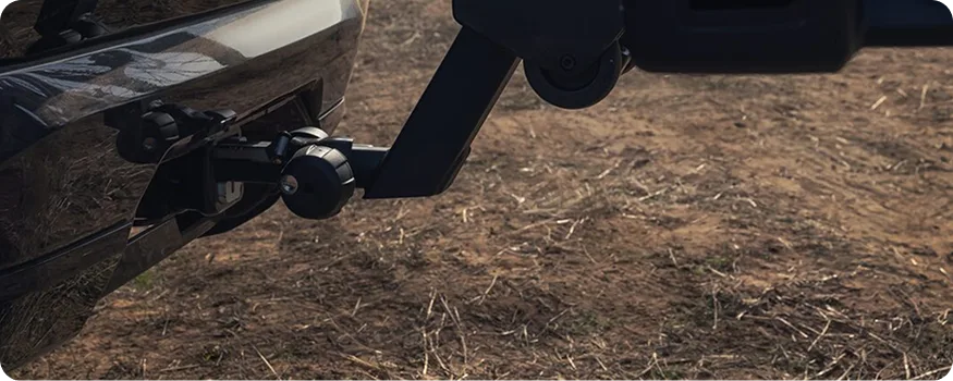 Close-up of the 2027 GMC Terrain's trailer hitch receiver and ball mount over dry grass