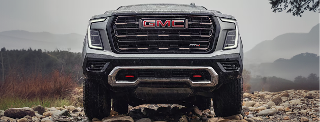 Front view of a silver GMC Yukon AT4 Ultimate on a rocky riverbed