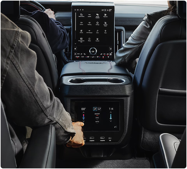 Second-row passenger adjusting the rear climate touchscreen in a GMC Yukon