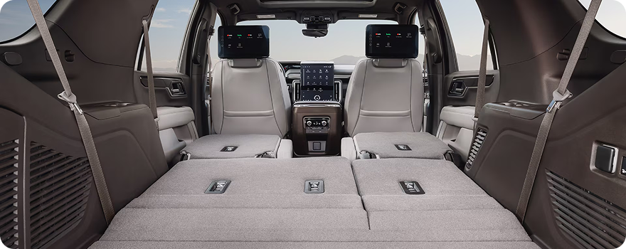 GMC Yukon cargo area with the second and third rows folded flat, seen from the open liftgate