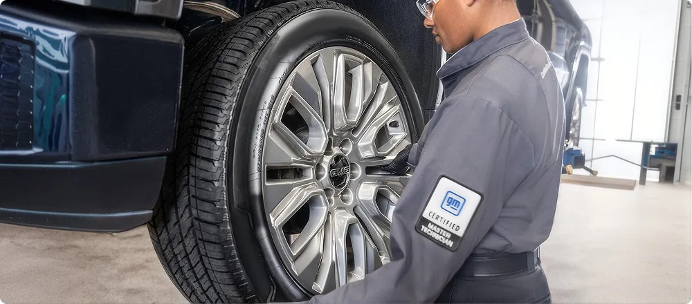 A technician fitting a tire to a wheel in the Phillips Buick GMC tire bay