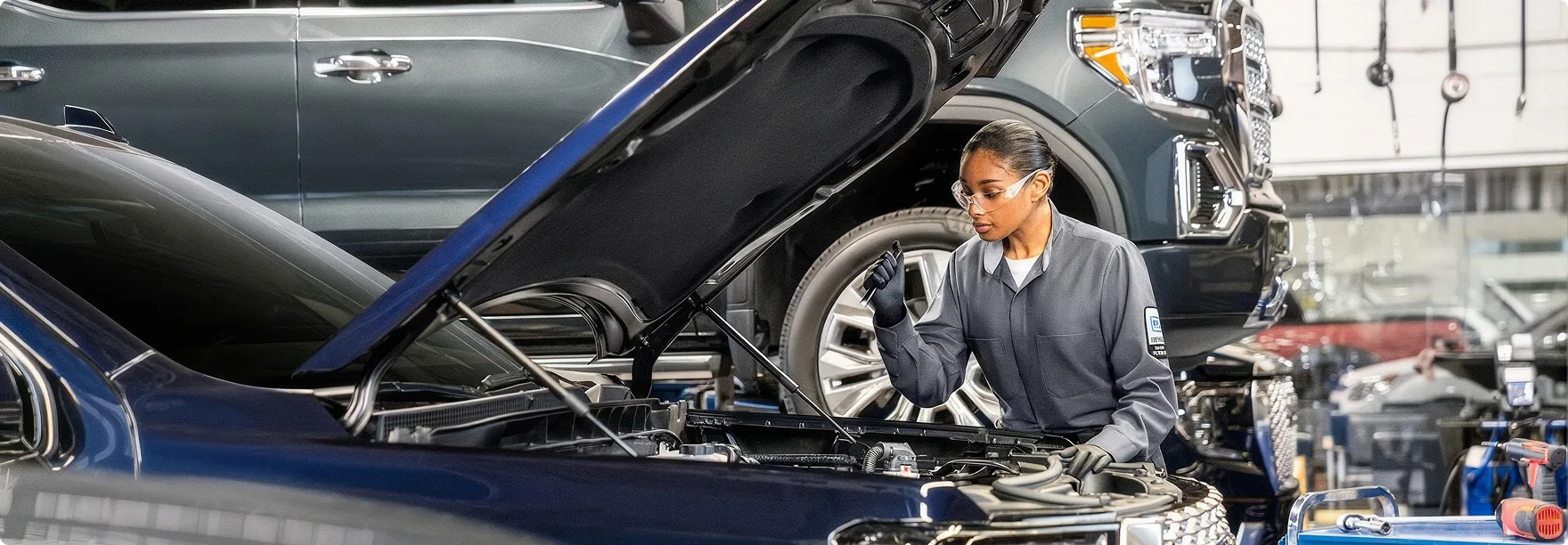 A Phillips Buick GMC technician carrying out a multi-point inspection on a raised vehicle